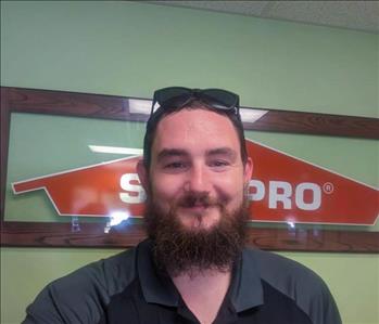 SERVPRO employee in front of SERVPRO sign