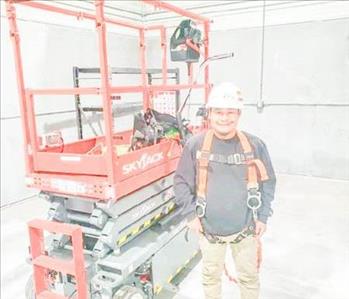 SERVPRO employee in front of warehouse equipment