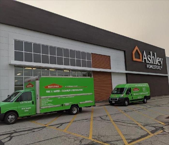 2 servpro trucks in front of ashley furniture store
