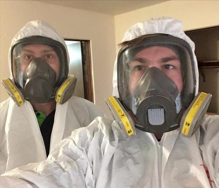 SERVPRO employees wearing full protective suits and masks.